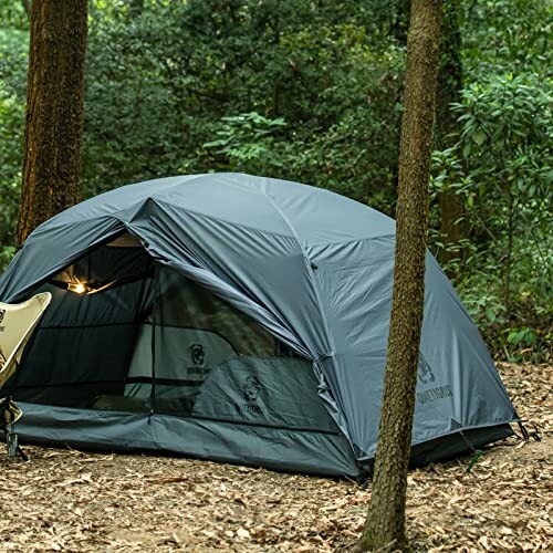 Gray camping tent set up in a forest