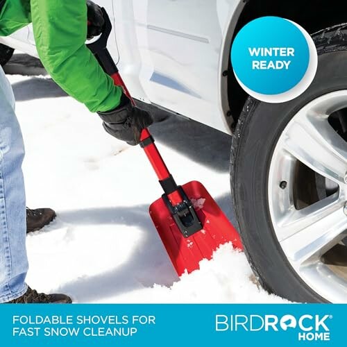 Person using a foldable snow shovel to clear snow near a car tire, demonstrating its practical use.