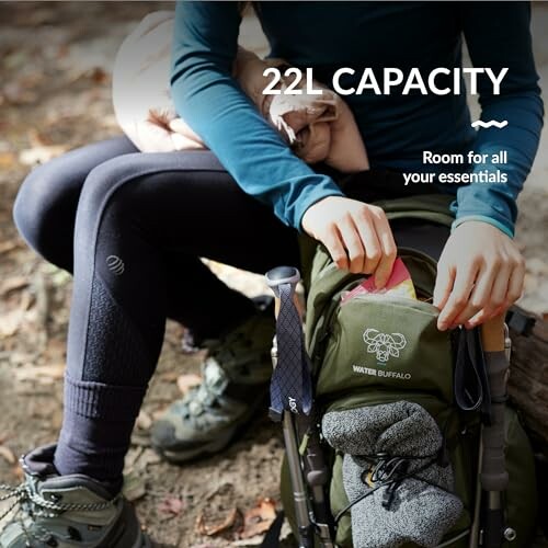 Hiker sitting with 22L capacity backpack, holding gear.