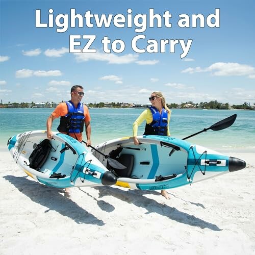Two people carrying lightweight kayaks on a beach.