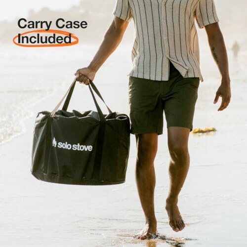 Man walking on the beach carrying a Solo Stove bag with a convenient carry case included.