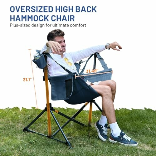 Man sitting in oversized high back hammock chair on grass.