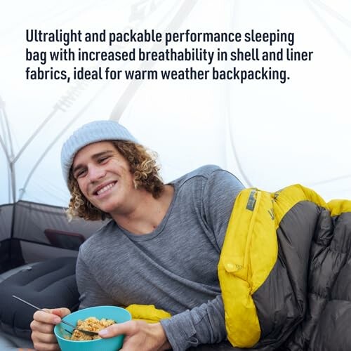 Person enjoying cereal in a sleeping bag inside a tent.