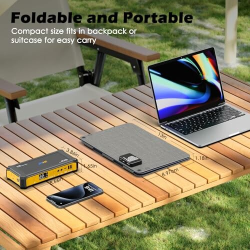 Foldable table with laptop, power bank, and smartphone, showcasing the device's ability to charge multiple devices at once.